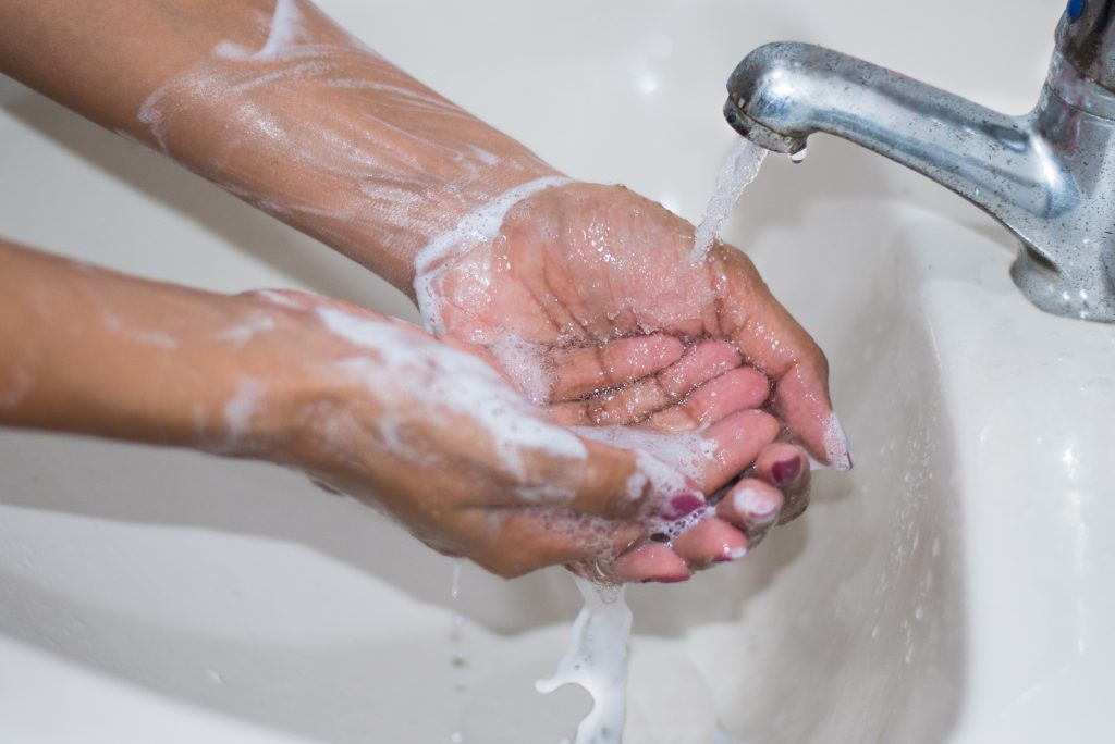 Image of hands being washed in a sink to help prevent the spread of covid 19