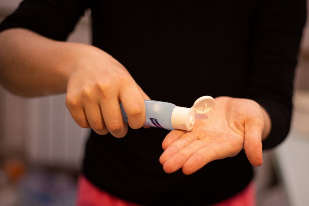 Image of person putting on hand sanitizer to help prevent the spread of covid 19